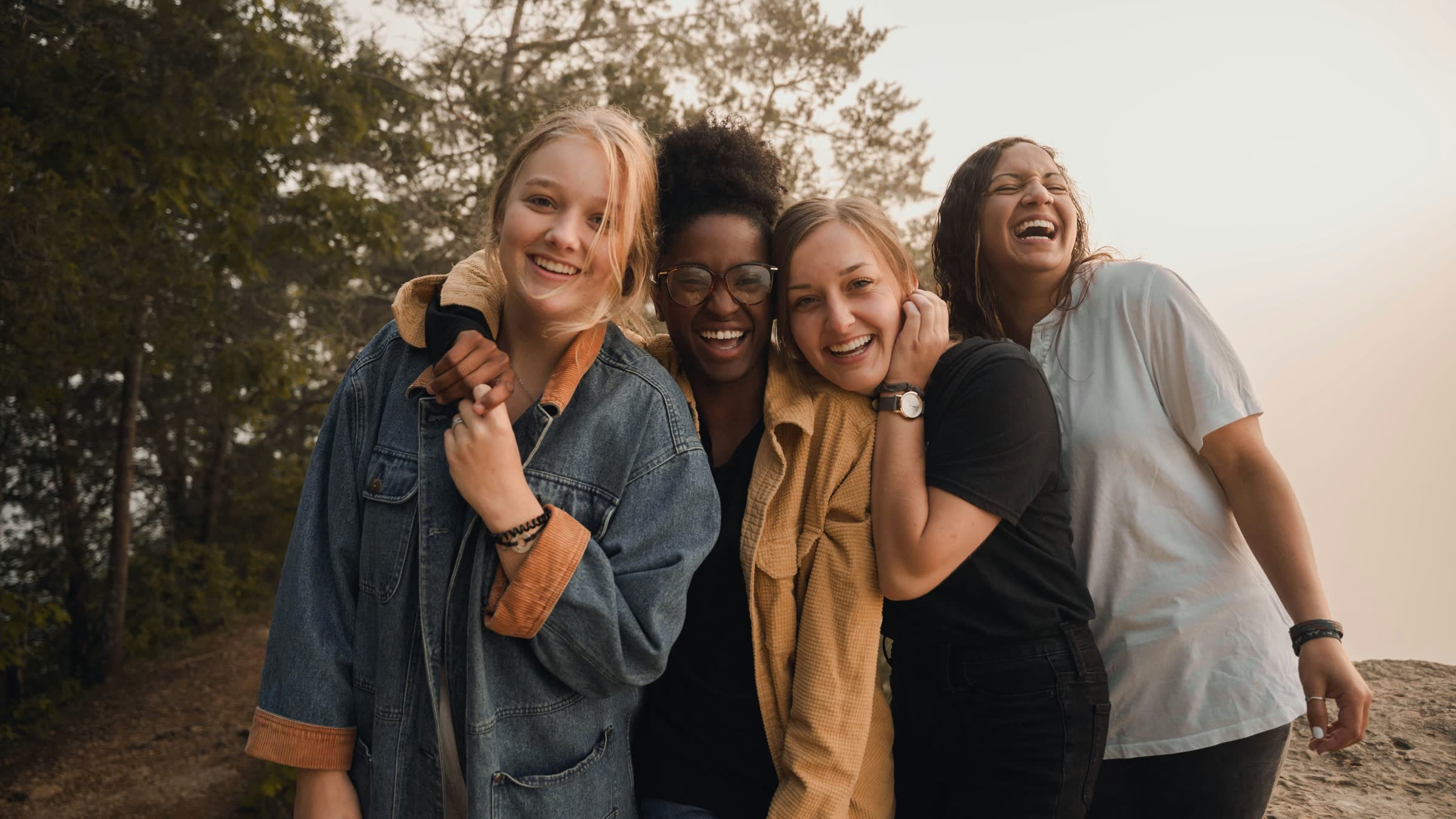 Four friends laughing together outdoors